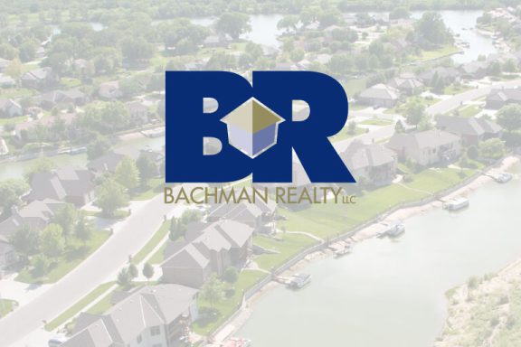 Bachman Realty logo over aerial view of development.