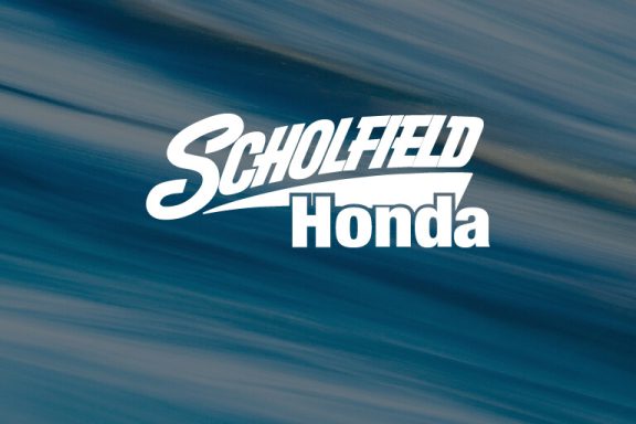Scholfield Honda logo over faded blue abstract pattern.